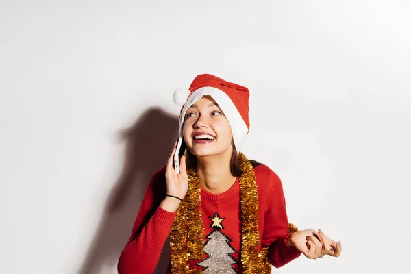 Heureux jeune fille dans une casquette rouge félicite ses amis avec la nouvelle année par téléphone — Photo