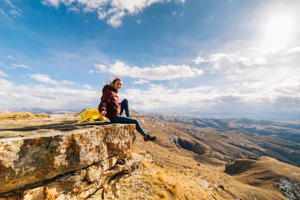 Активна молода дівчина веде здоровий спосіб життя, багато подорожує, сидить на краю гори — стокове фото