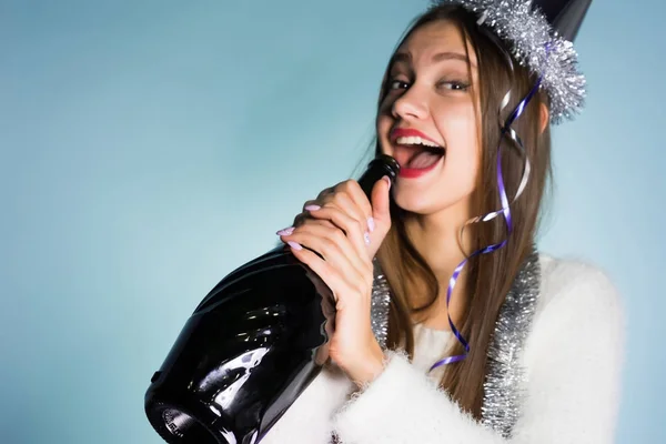 Смеющаяся пьяная девушка с красной помадой празднует Новый 2018 год, пьет шампанское из бутылки — стоковое фото