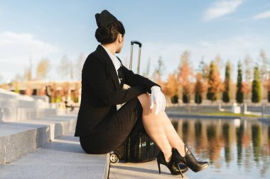 Hostes basamaklarında oturan bir siyah çanta