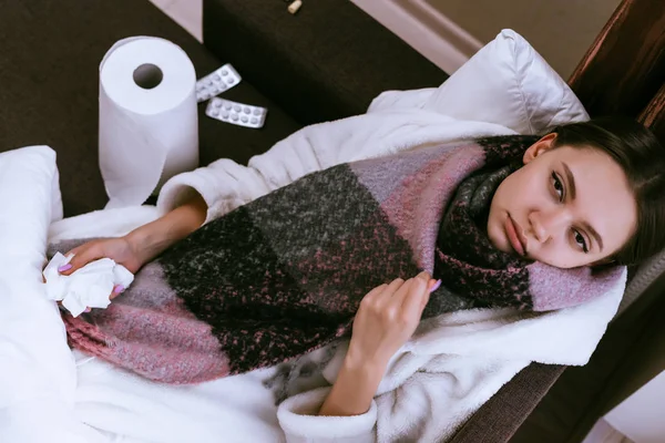 Young girl lies in bed and takes pills from illness — Stock Photo, Image
