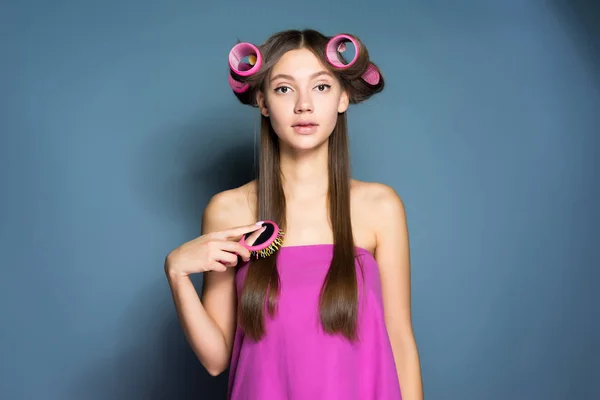 大きなカーラーで髪を梳く彼女の頭の上の少女 — ストック写真
