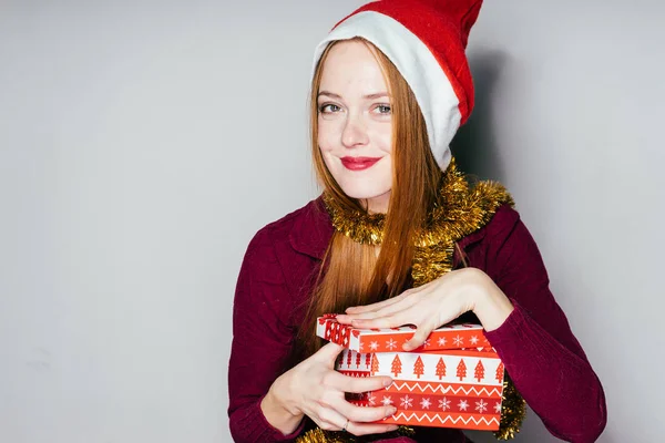 Das Mädchen mit dem Neujahrsmütze hält die Hände einer Geschenkbox — Stockfoto