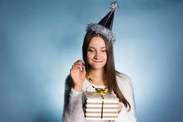 Jong meisje op een witte achtergrond is gonna opent haar cadeau — Stockfoto
