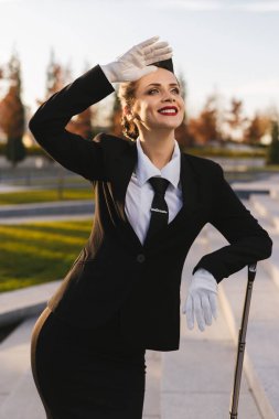 gülümseyen güzel hostes kız üniformalı kırmızı ruj gökyüzüne bakarak