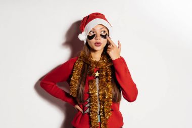 gözleri, kırmızı bere ve kazak, boynunda altın bir tinsel altında siyah yamalar ile garip bir kız