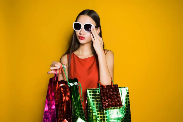 Stijlvolle, modieuze meisje shopaholic in zonnebril gekocht vele giften voor het nieuwe jaar — Stockfoto