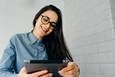 gözlük gülümseyen güzel kız öğrenci tablet görünüyor