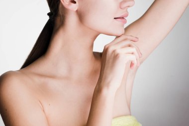 Cilt Bakımı altında koltuk altı gri bir arka plan üzerine genç kız yürütmektedir