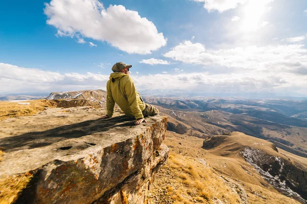 Young tourist guy admiring the scenery of mountains on a sunny day — Stock Photo, Image