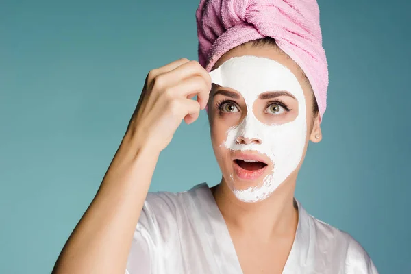 Chica con una toalla en la cabeza quita una mascarilla limpiadora —  Fotos de Stock