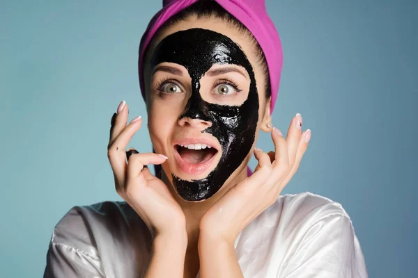 Dziewczyna z różowy ręcznik na głowie stosowane oczyszczanie maski na twarzy — Zdjęcie stockowe