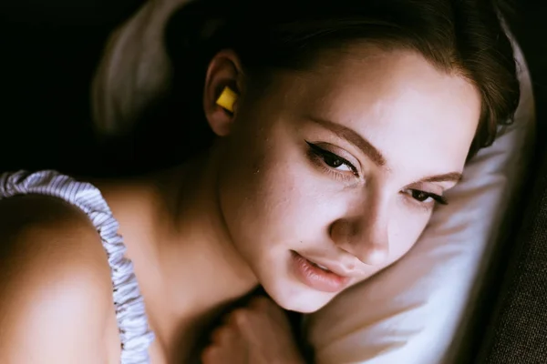 Ładna, młoda dziewczyna, spanie w uszy żółte zatyczki do uszu przeciw hałas z ulicy — Zdjęcie stockowe