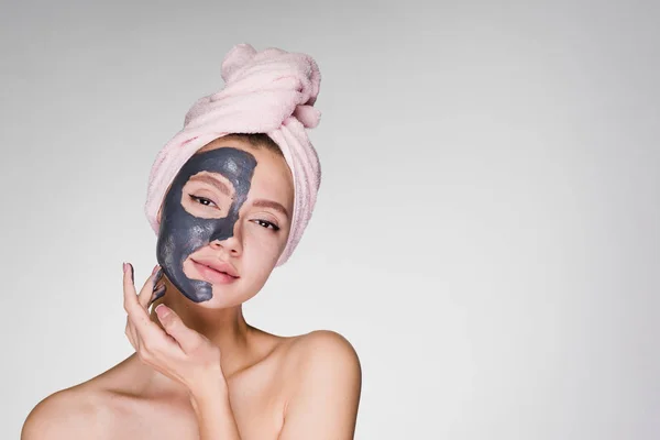 Atrakcyjna, młoda dziewczyna z różowy ręcznik na głowie stosowane maski gliny przydatne — Zdjęcie stockowe