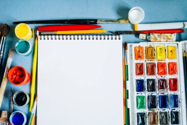 mavi bir masada çizim kağıt, suluboya ve guaj bir beyazdır