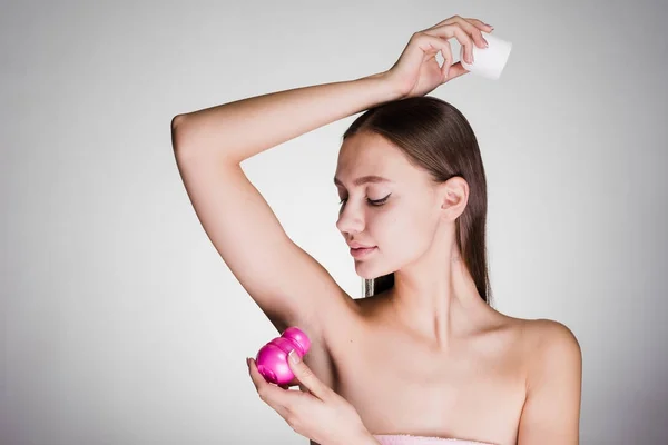 Привлекательная молодая девушка наносит дезодорант на подмышки — стоковое фото