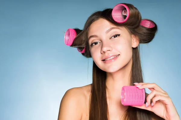 Χαμογελώντας όμορφο κορίτσι κάνει ένα κομψό χτένισμα με ένα μεγάλο ροζ μαλλιά μπικουτί — Φωτογραφία Αρχείου