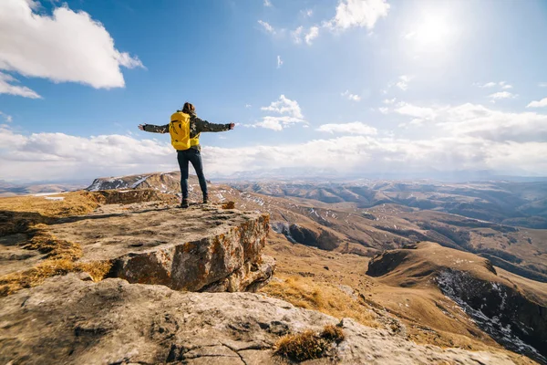 Young girl travels through the Caucasian mountains with a yellow backpack — Stock Photo, Image