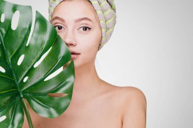 güzel genç kız başında bir havlu ile büyük yaprak yeşil, onun elinde tutan bir spa gün