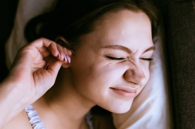 bir genç kız yatak, değil için onun kulaklarında kulak tıkacı gürültü karşı koymak gitti