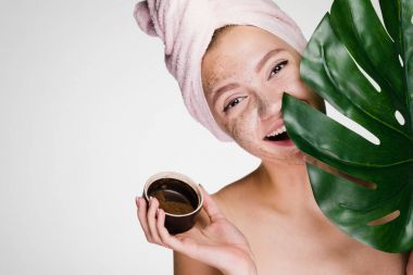 Kafasındaki pembe havlu ile gülümseyen kız mutlu bir kahve Maki yüzünde day Spa'da uygulanan