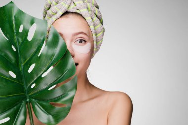 Kafasındaki bir yaprak yeşil gözleri yamalar, günlük bakım altında tutan bir havlu ile genç kız