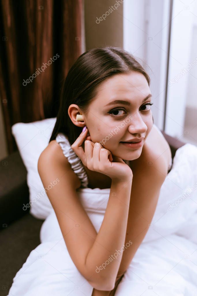 nice young girl going to sleep, plugged earplugs against street noise