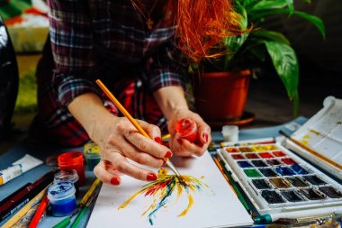 kadın ressam boyalar bir fırça ve boya ile beyaz kağıt üzerinde