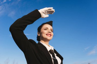 mutlu güzel hostes kız mavi gökyüzüne karşı uçağı için bekliyor