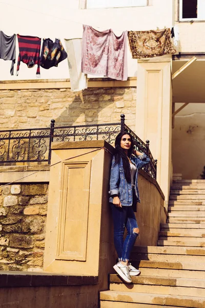 Стильная темноволосая девушка-путешественница позирует против красочной архитектуры города Баку — стоковое фото