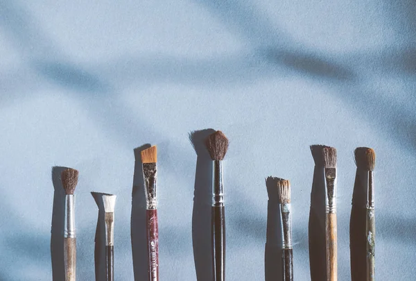 mavi bir arka plan üzerinde sanatsal fırçaların farklı boyutlarda vardır