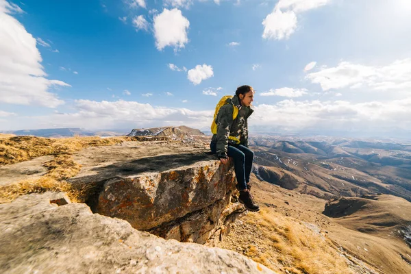 Aktif genç kız gitti, bir uçurumun kenarında oturur ve doğa sever — Stok fotoğraf