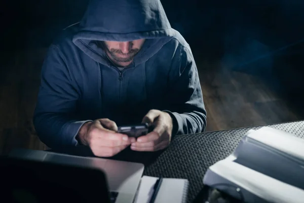 Homme criminel mystérieux pirate smartphone dans l'obscurité — Photo