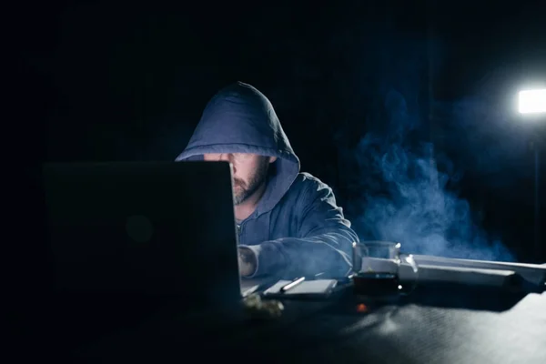 Μυστηριώδη ποινικές αρσενικό χάκερ κάνουν κάτι παράνομο σε ένα φορητό υπολογιστή στο σκοτάδι — Φωτογραφία Αρχείου