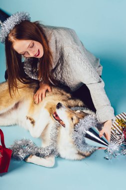 mutlu gülümseyen Kızıl saçlı kız köpeğini, Noel atmosferi ile yeni yıl kutlama