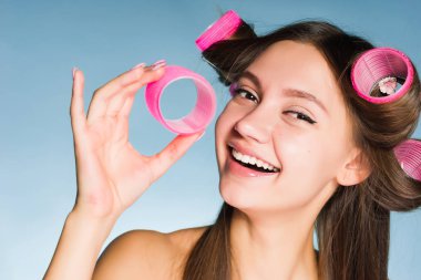 mutlu gülümseyen kız moda saç modeli curlers ile yapıyor