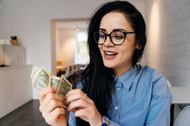 dolar çok para verme onun elinde tutan gözlüklü genç akıllı kız gülümseyerek