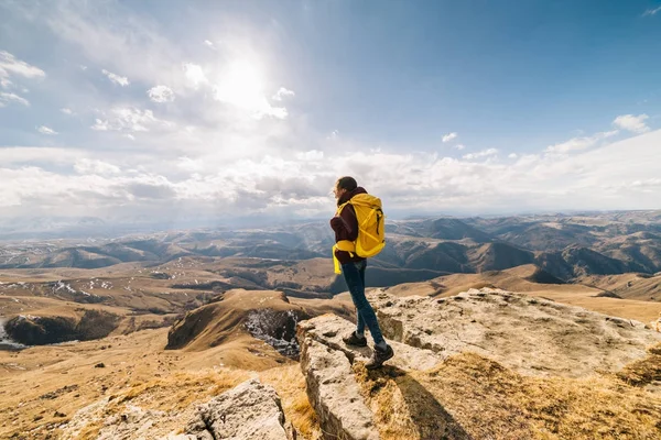 Активная молодая девушка путешествует, с желтым рюкзаком, наслаждается чистым горным воздухом — стоковое фото