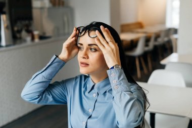 genç güzel kız öğrenci üniversitede dersler sonra kafede oturan gözlük ve mavi gömlekli