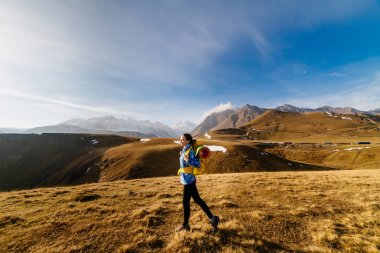 mavi bir ceket ve aktif genç kız bir sırt çantası ve çadır ile beyaz sırt boyunca seyahat