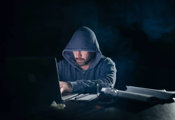 Misterioso criminoso homem hacking laptop no escuro — Fotografia de Stock