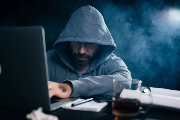 Mysterieuze bebaarde man een laptop hacks, verbergt zijn gezicht onder de motorkap — Stockfoto