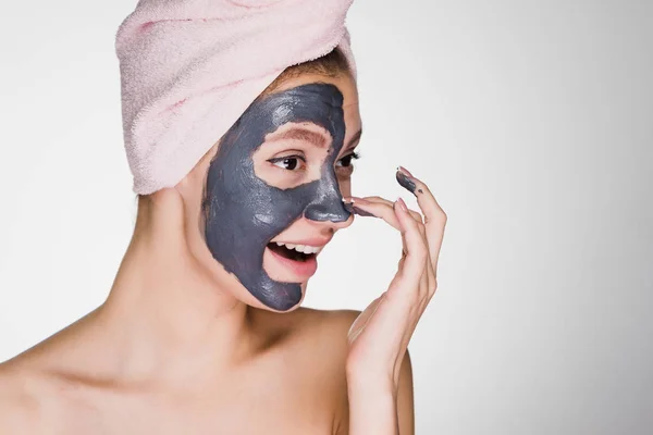Menina sorridente feliz fazendo procedimento de spa, máscara de barro na metade do rosto — Fotografia de Stock