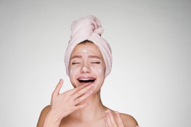 genç bir kız beyaz bir maske onun yüzüne koydu esnemek