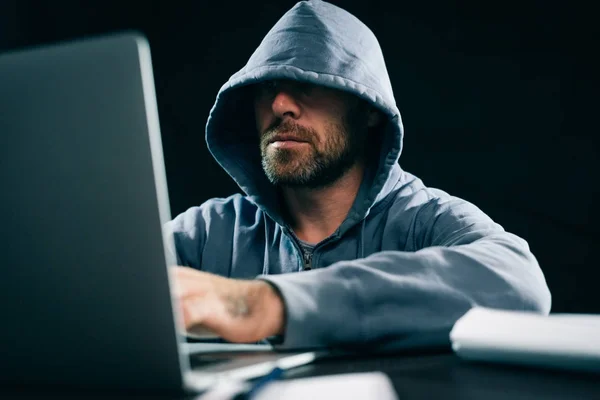 Um hacker experiente está hackeando sentado para laptops — Fotografia de Stock