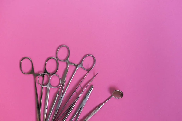 Viele zahnärztliche Instrumente auf einem rosa Tisch — Stockfoto