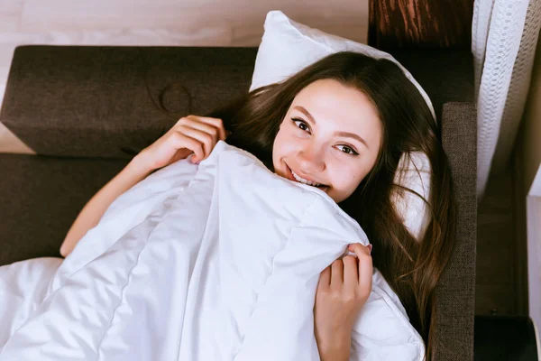 Junges Mädchen lächelt im Bett liegend und bereitet sich auf den Schlaf vor — Stockfoto