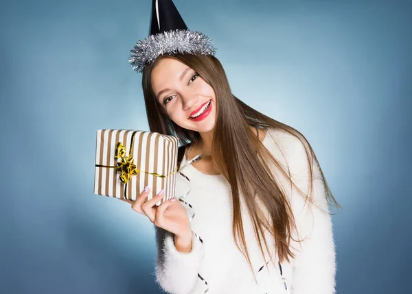 Glückliches Mädchen auf weißem Hintergrund hält ein Neujahrsgeschenk in der Hand — Stockfoto