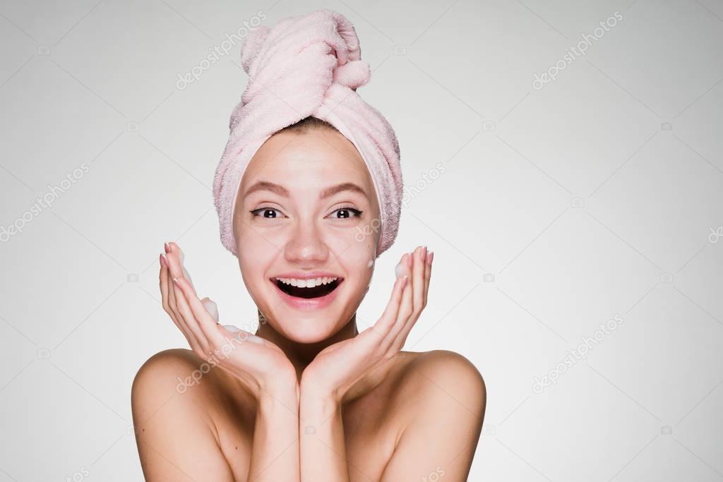 young smiling girl puts on face cream