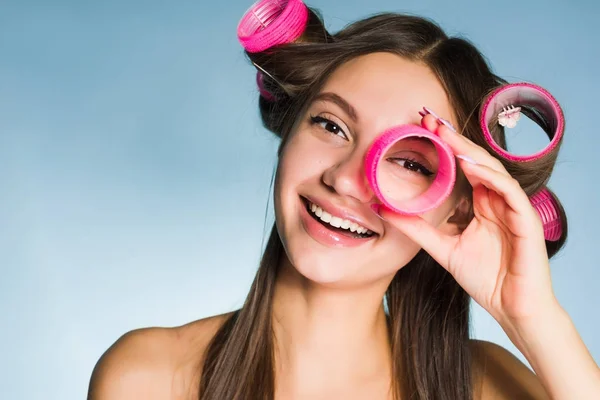 Carina ragazza sorridente vuole un'acconciatura alla moda, tiene un grande bigodino rosa — Foto Stock